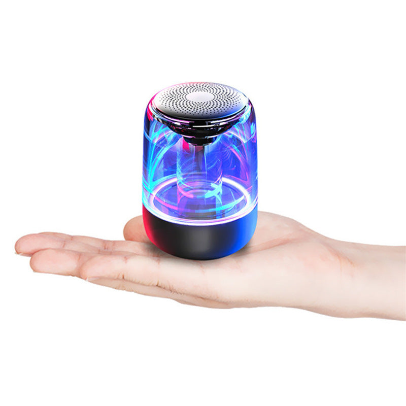 Portable Bluetooth speaker with colorful LED lights and powerful bass displayed on a hand.
