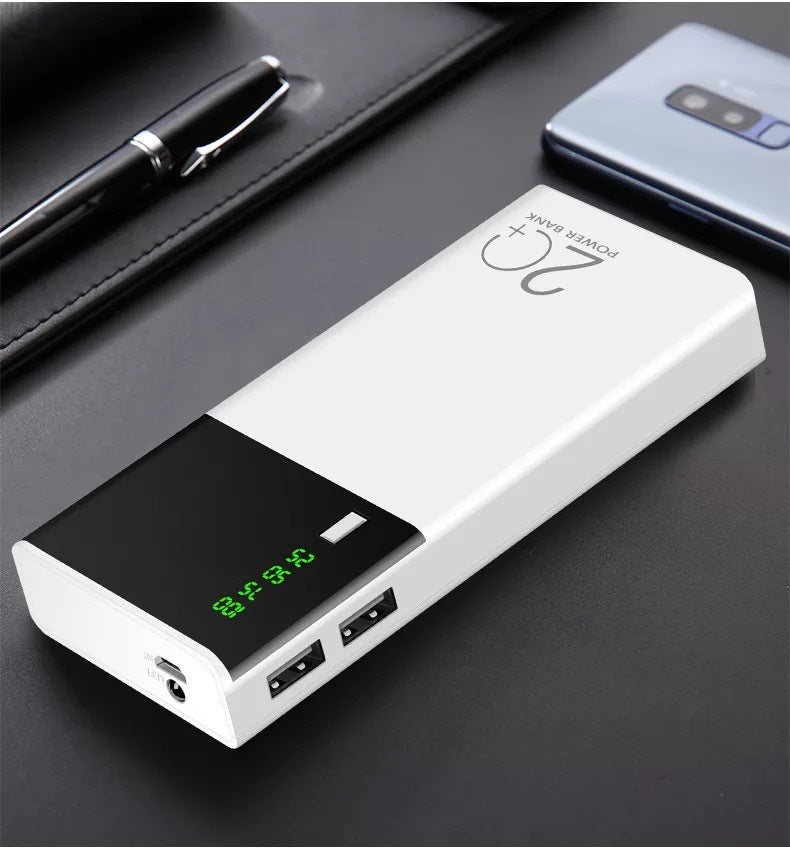 20000mAh black and white power bank with dual USB ports on a desk.