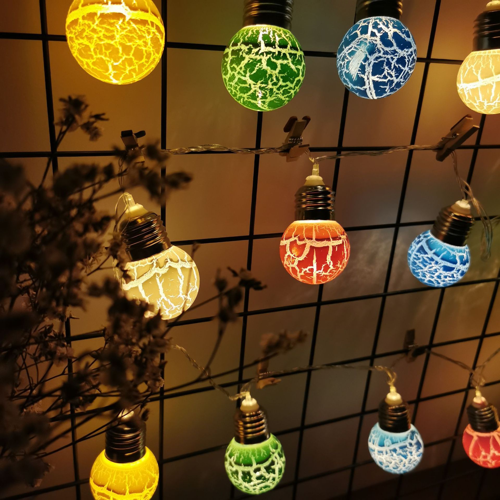 Colorful LED lights with cracked bulb design hanging on a string for festive decoration