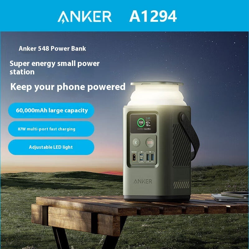 Green Dynamic Power 60000mAh outdoor power bank with multi-output ports and plastic shell on a table at night.